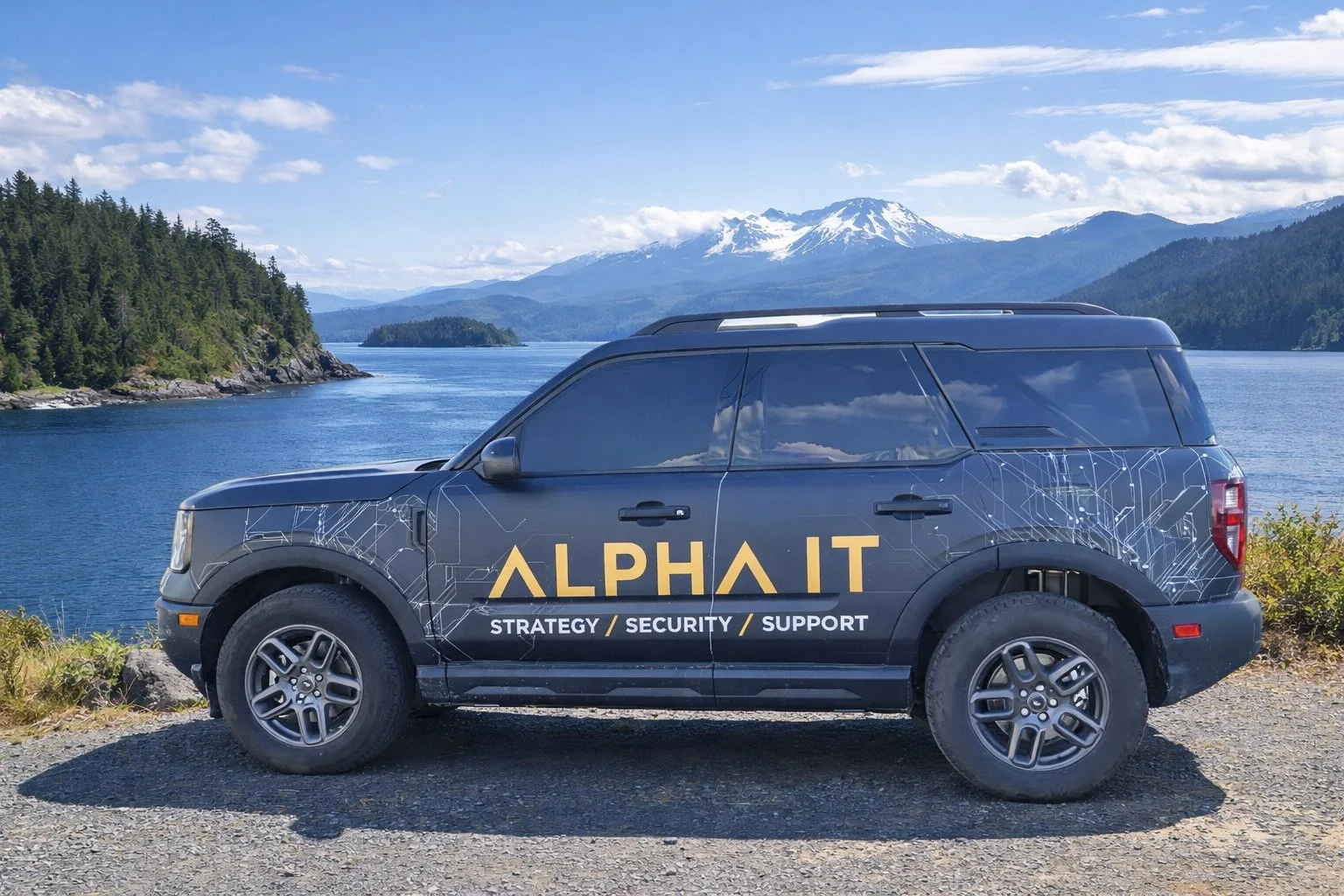 ALPHA IT branded Ford Bronco on Vancouver Island coastline with mountains and ocean